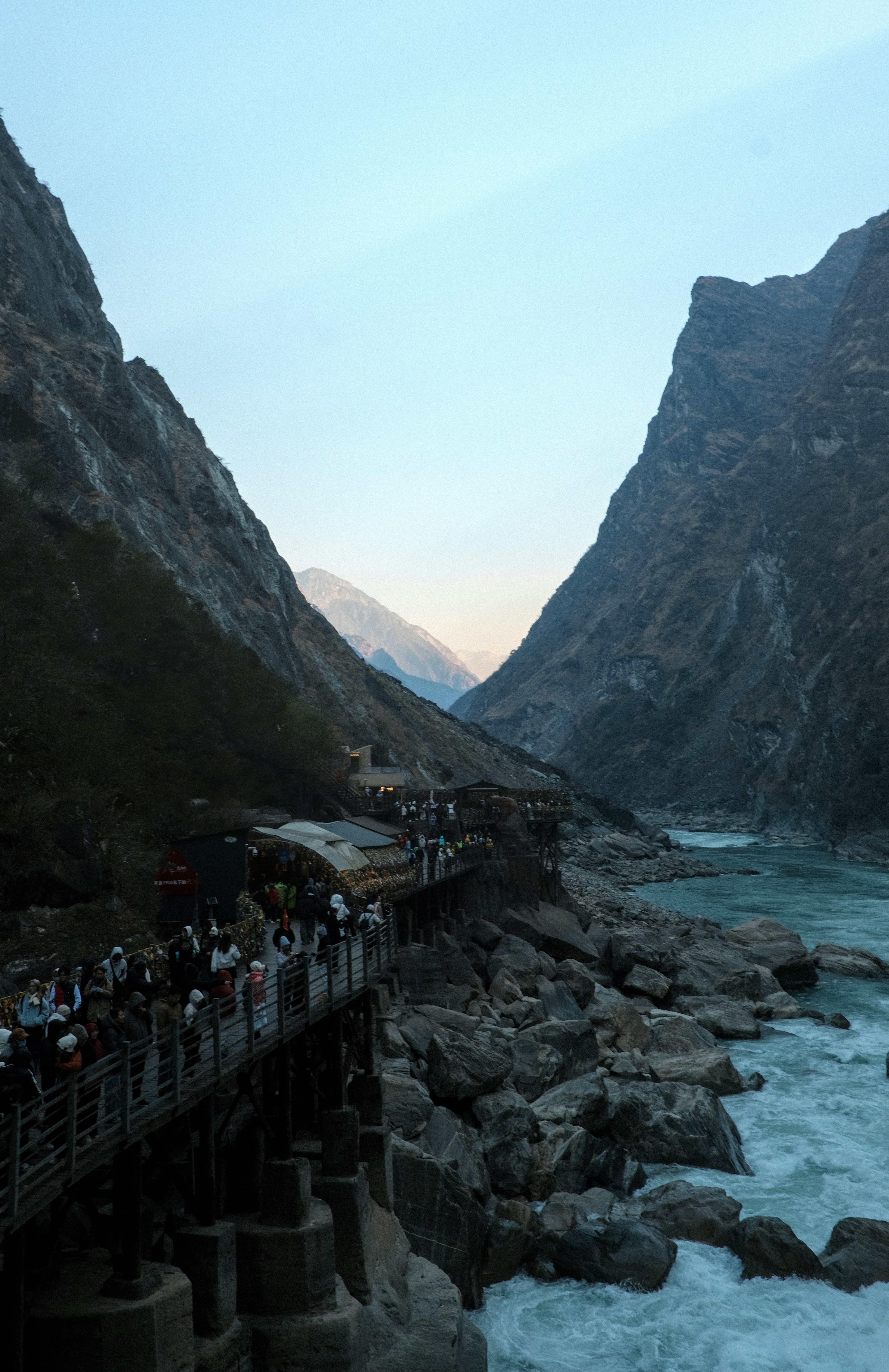 A scenic mountain gorge with a river and a walkway.
