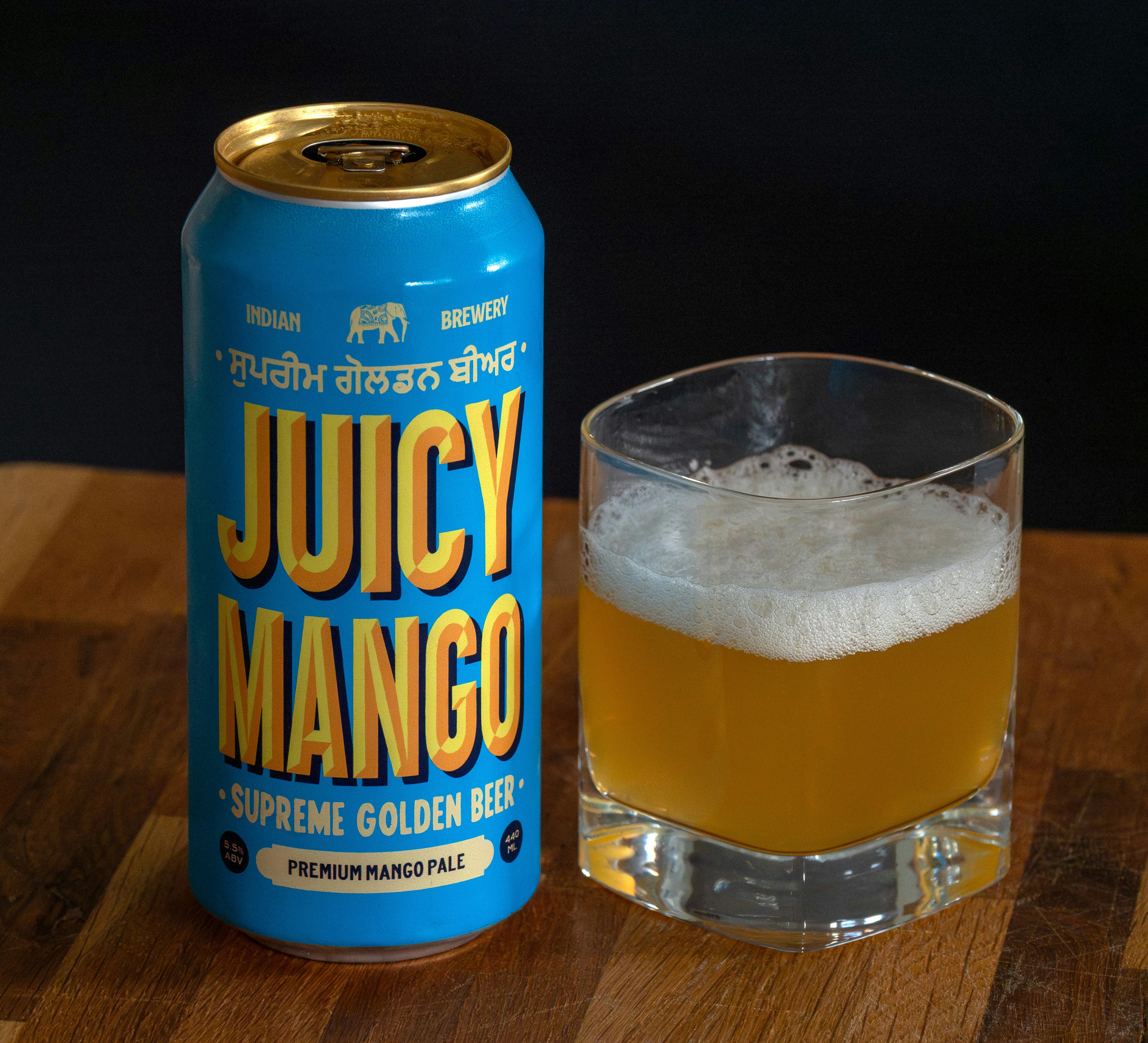 A can of juicy mango beer next to a glass