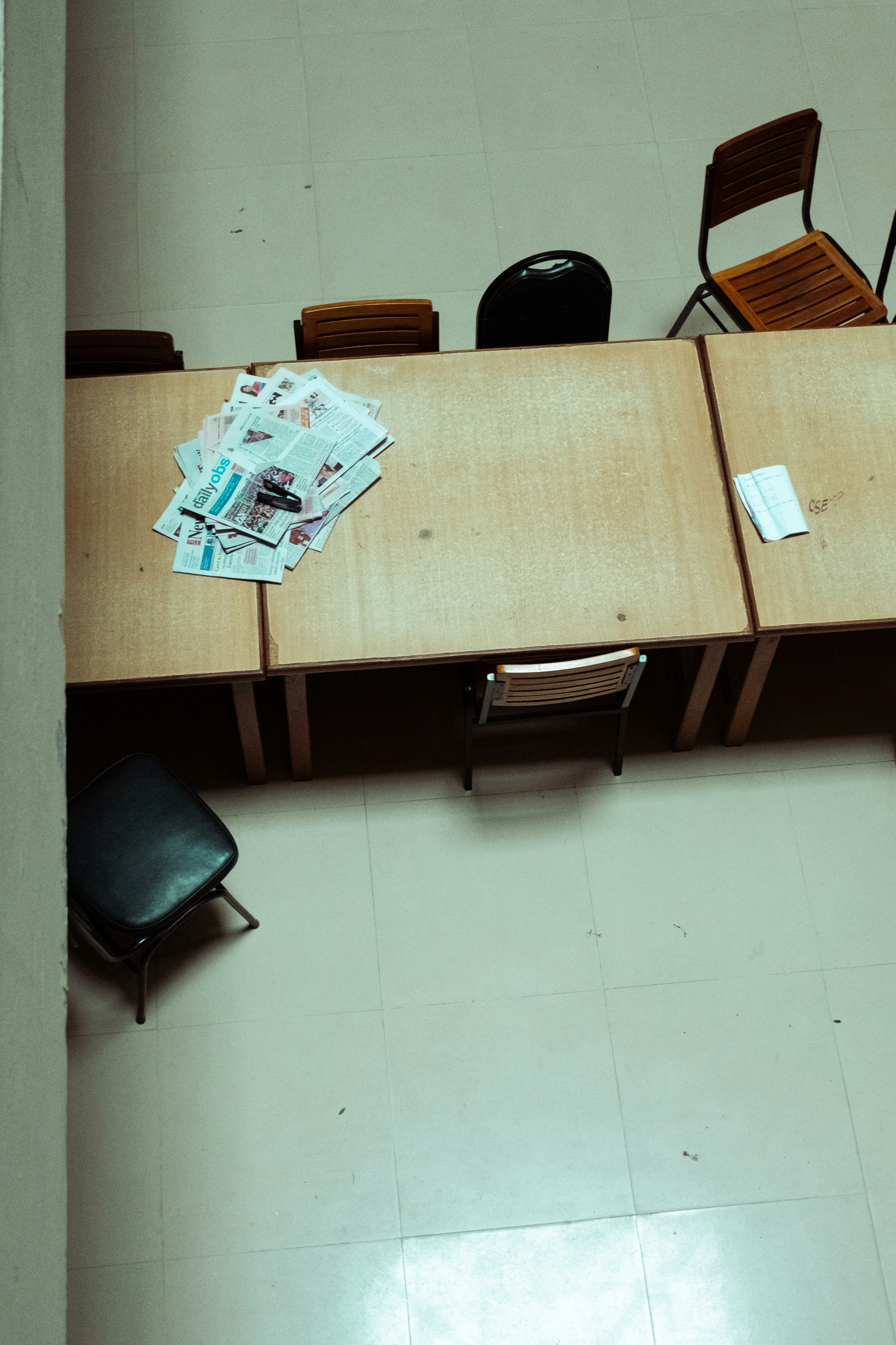 A table with chairs and newspapers in-tray of newspapers