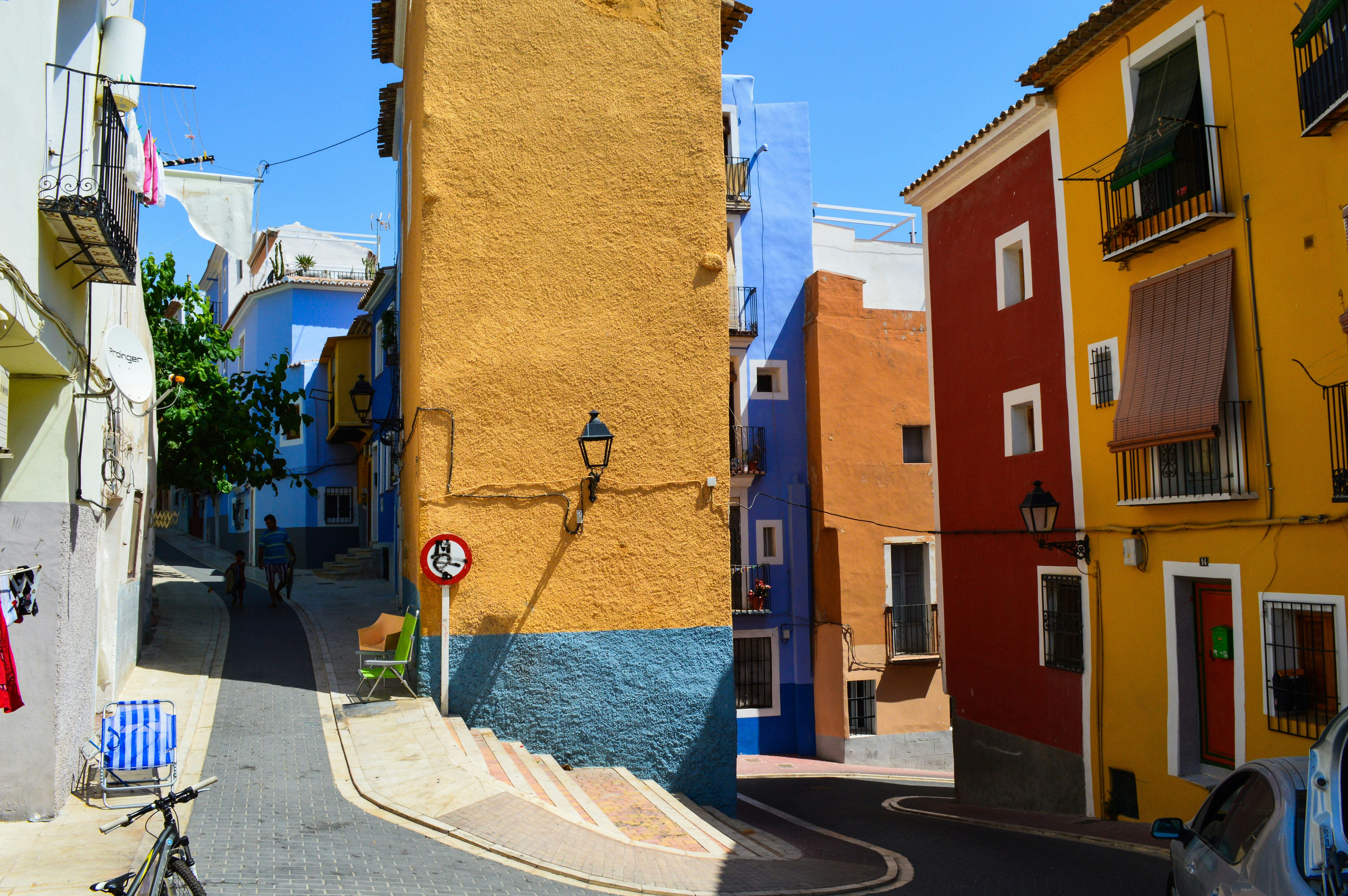 Colorful buildings line a narrow street in a town.