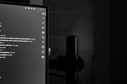 Computer monitor displaying code in a dark room.