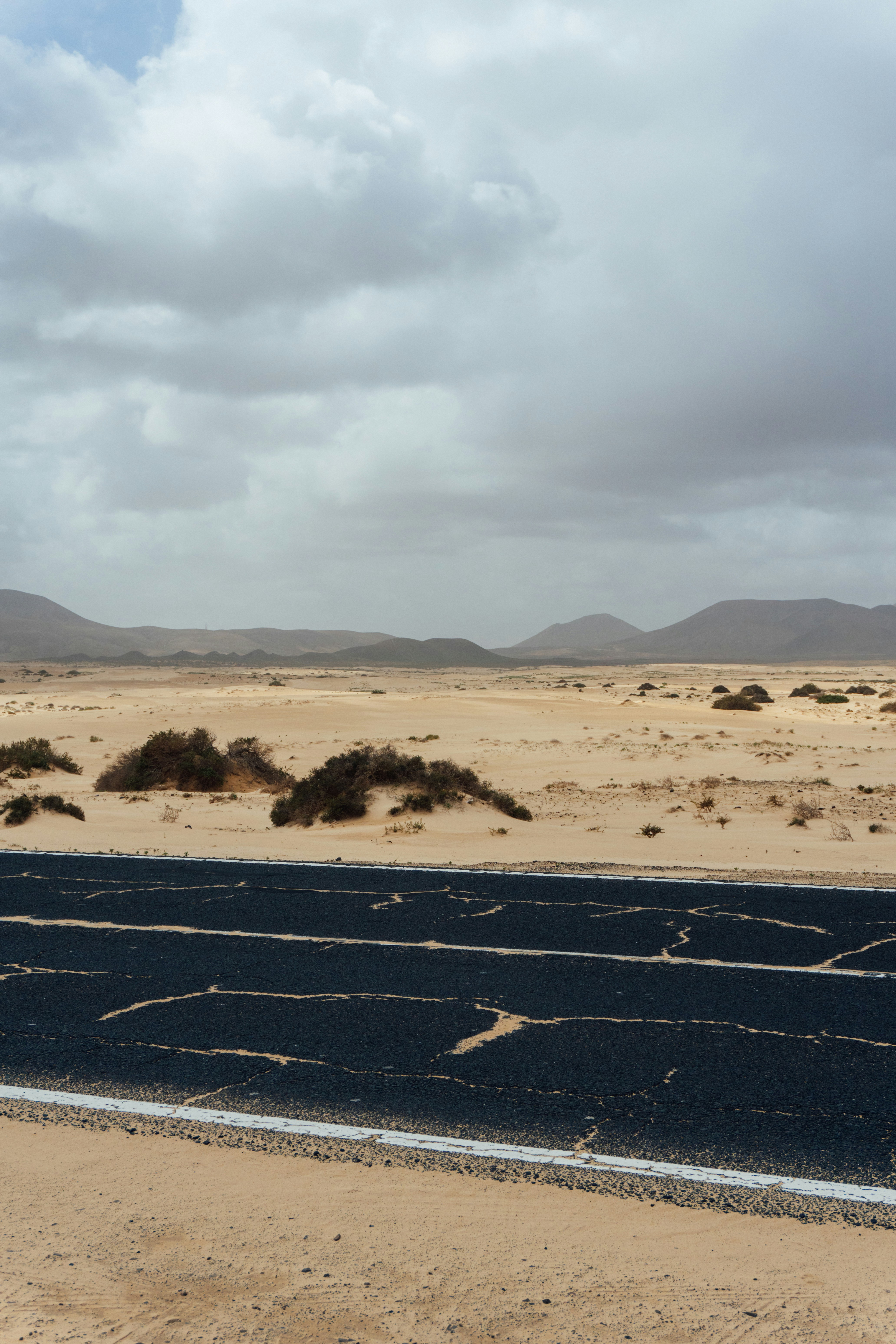 Desert landscape with cracked asphalt road ahead