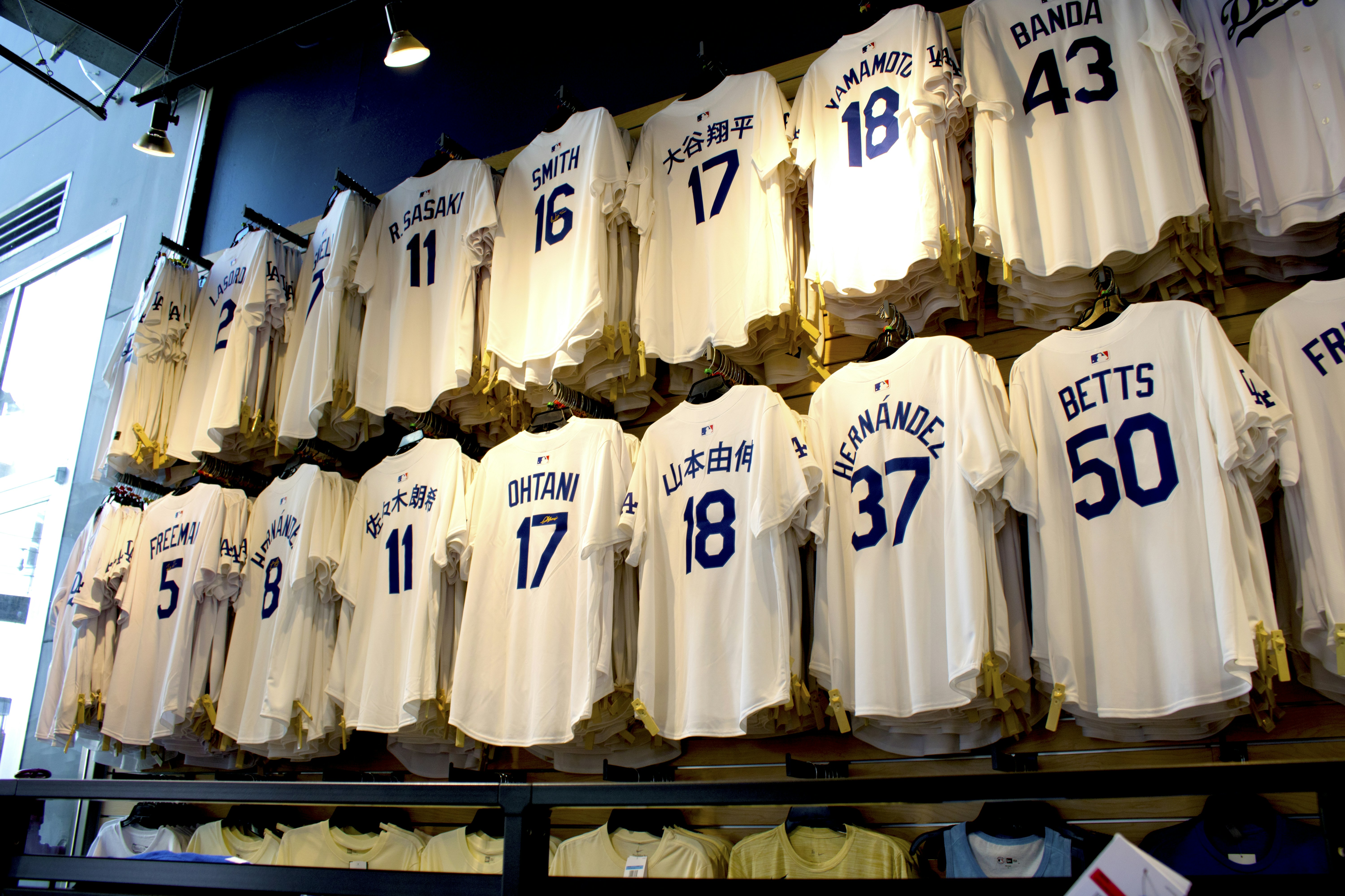 Hinchas observando camisetas de fútbol en una tienda deportiva