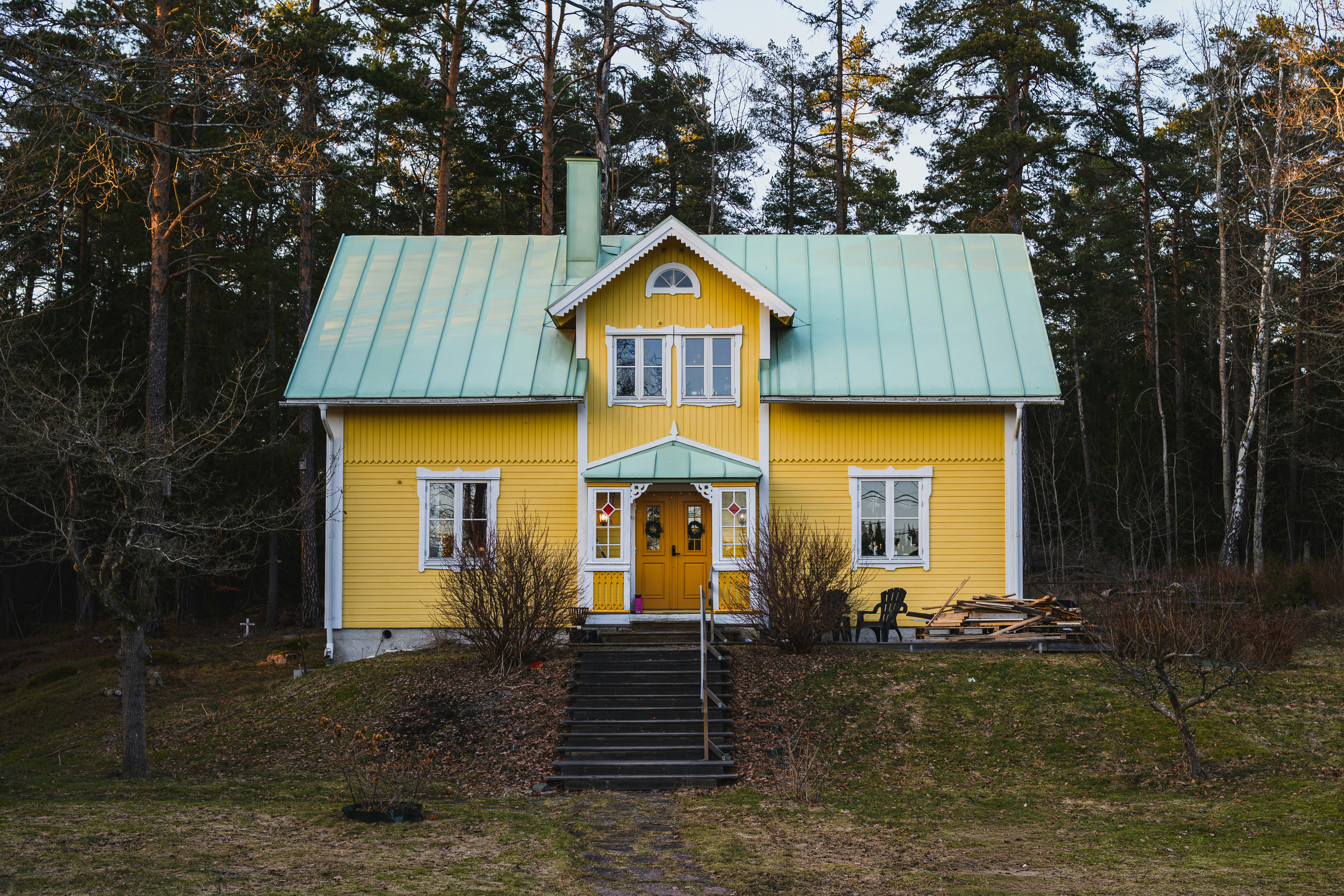 A bright yellow house with a green roof.