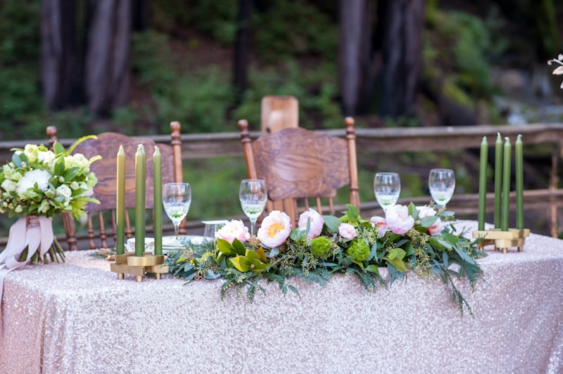 Wedding reception table setting with candles and greenery