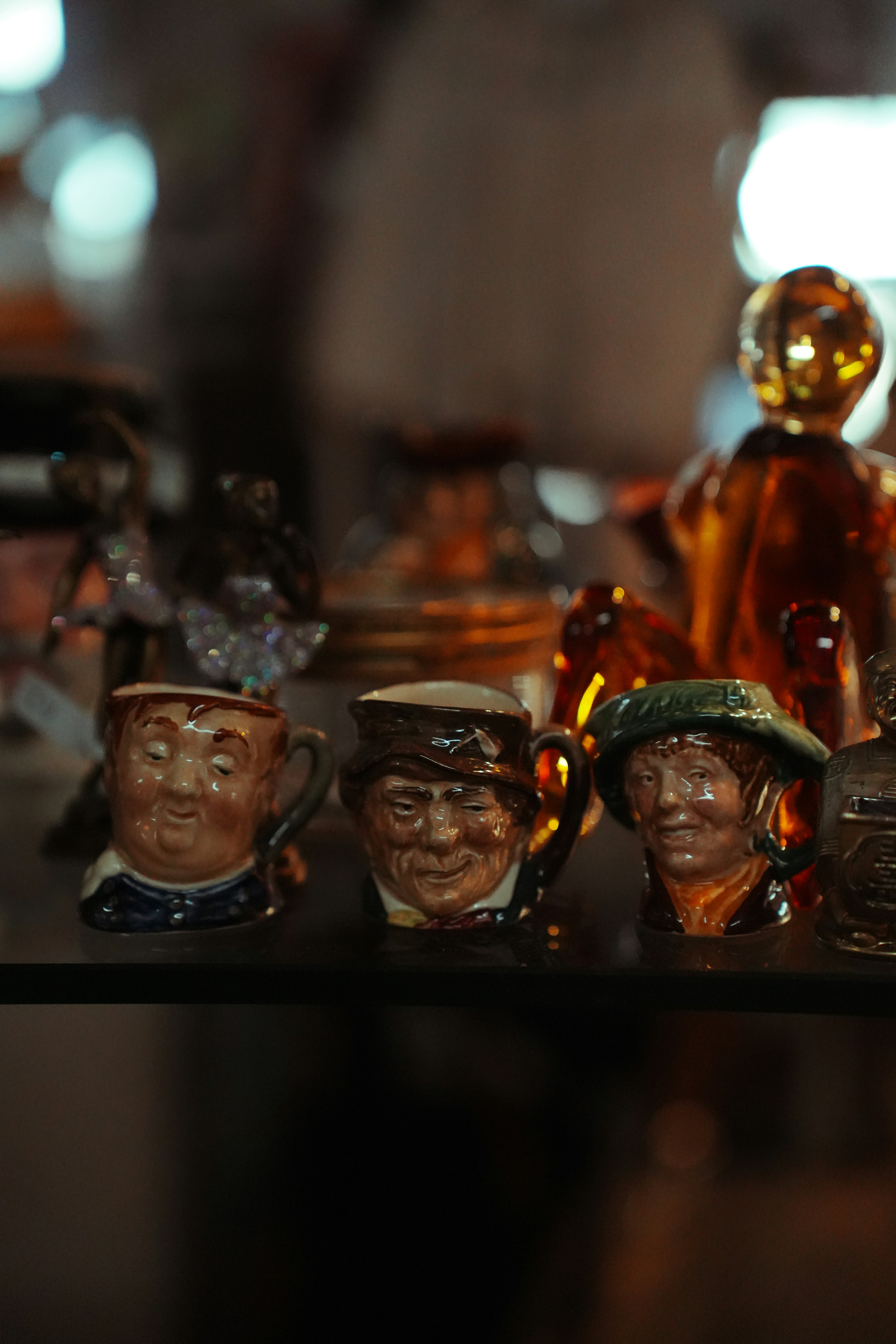 Three ceramic mugs with caricatured faces.