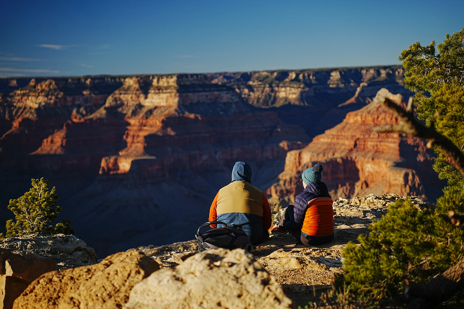 Two hikers looking over the Grand Canyon at sunrise, where mobile coverage in US national parks is limited