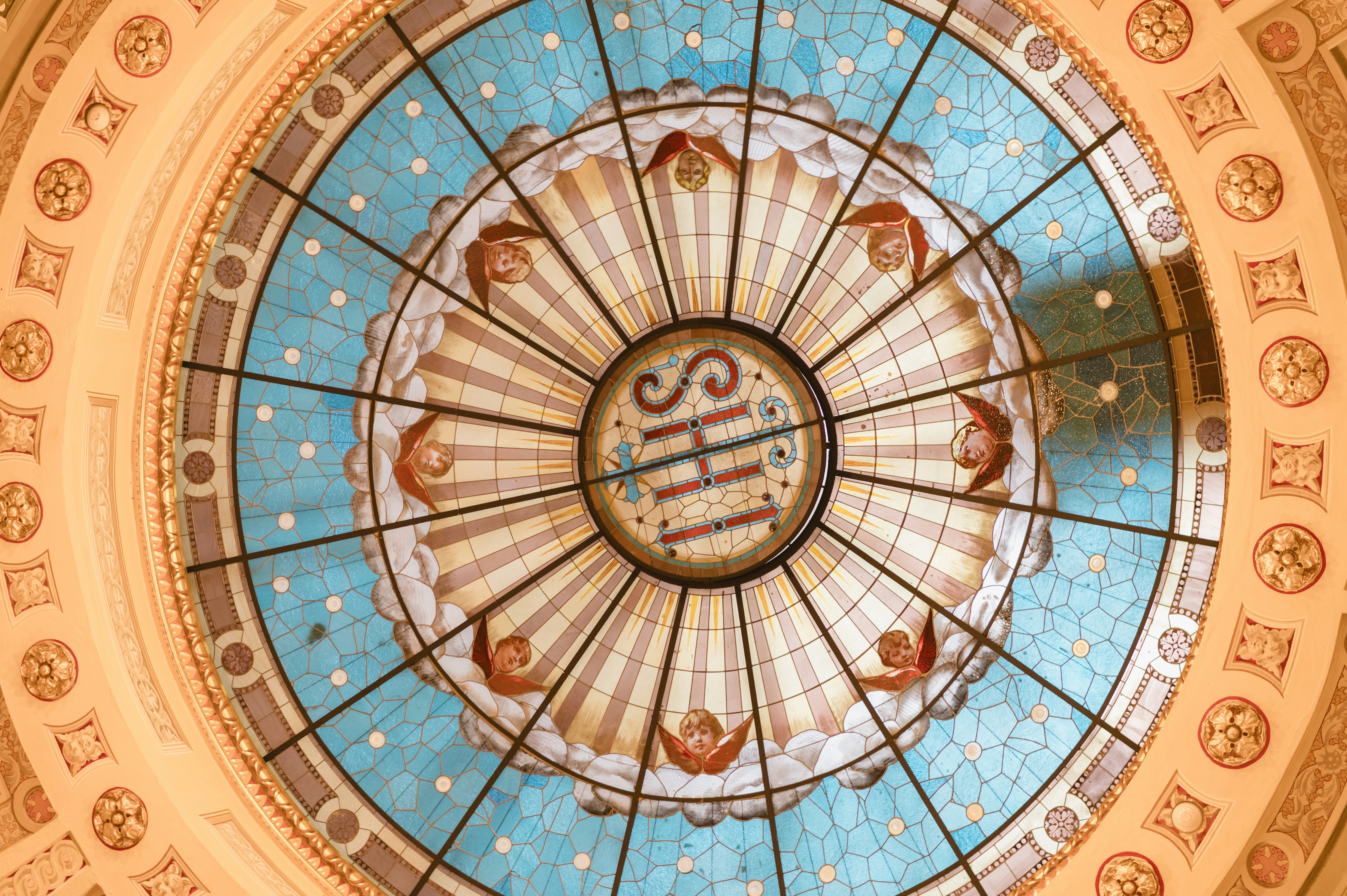 Intricate stained glass dome with religious symbols.