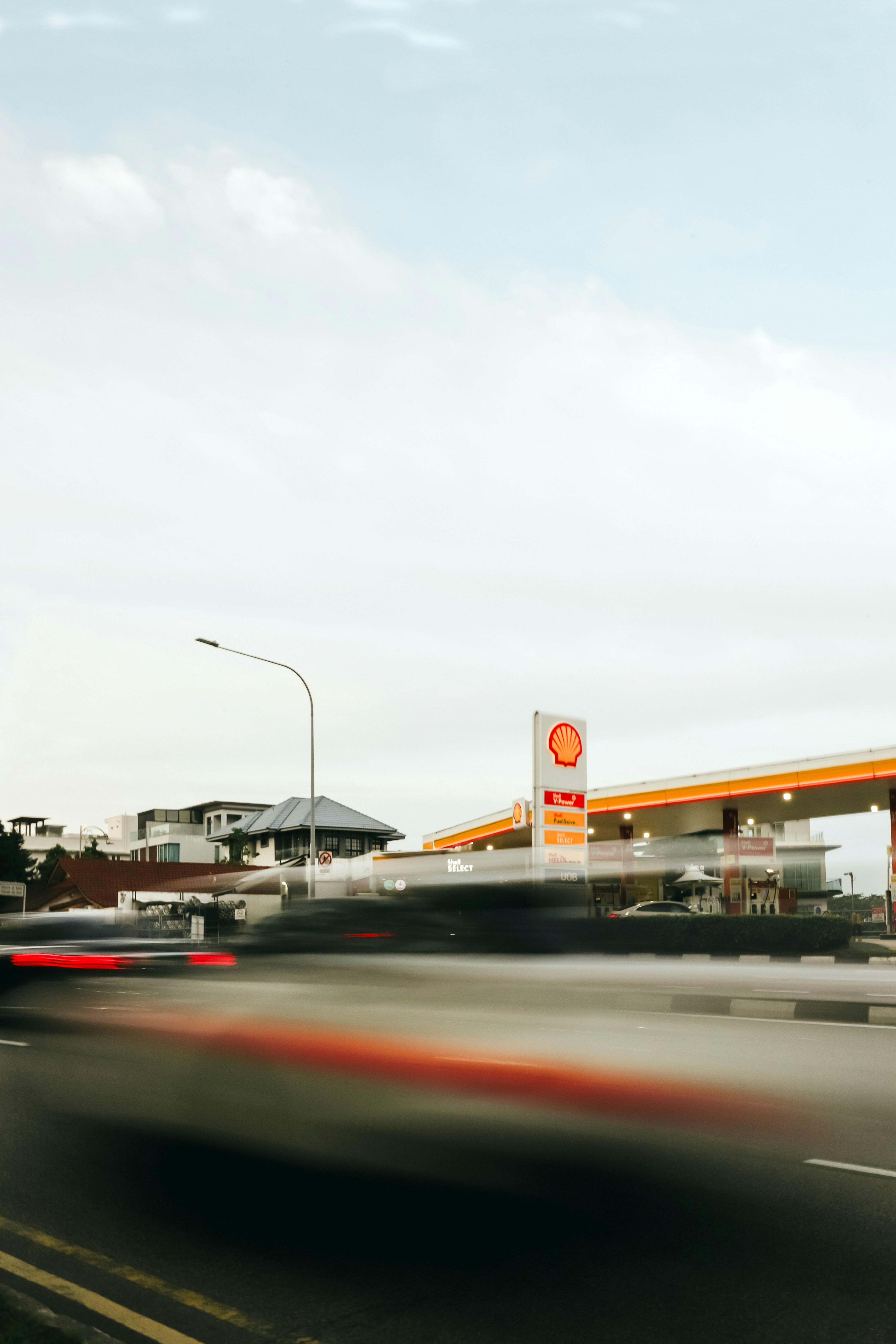 Posto de gasolina Shell com carros borrados passando