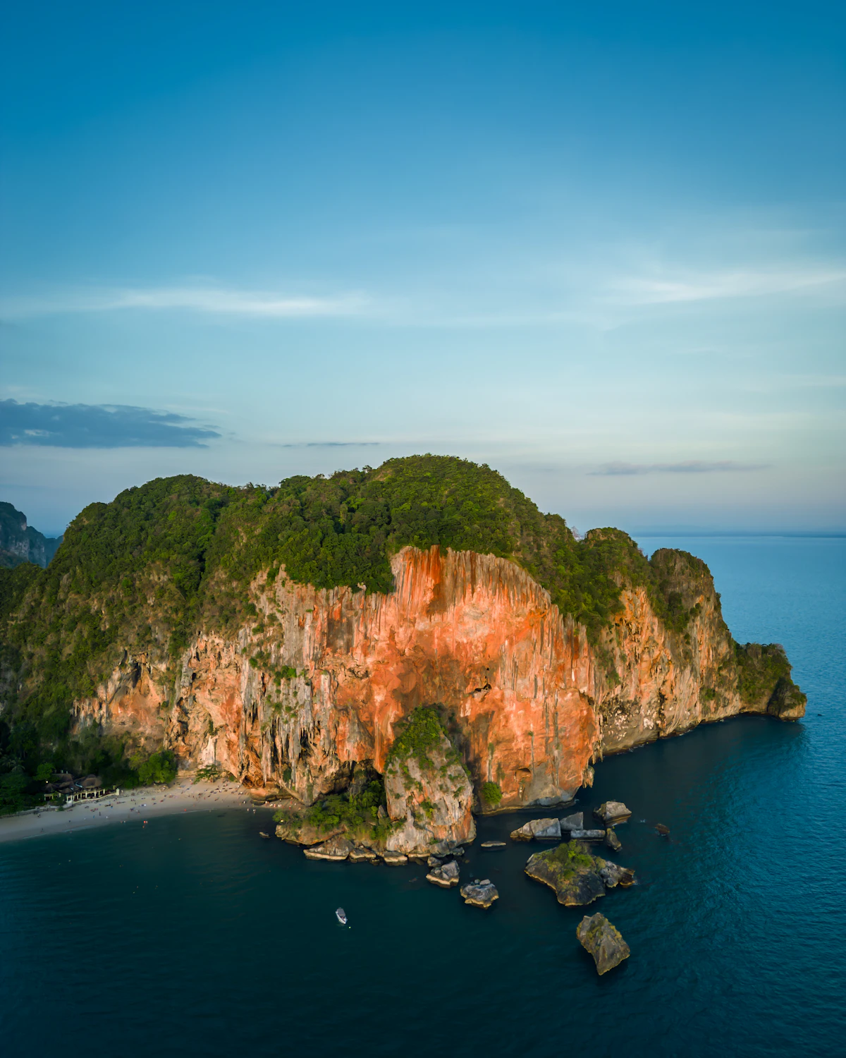 The orange limestone headland at Railay rising from the Andaman Sea, Krabi