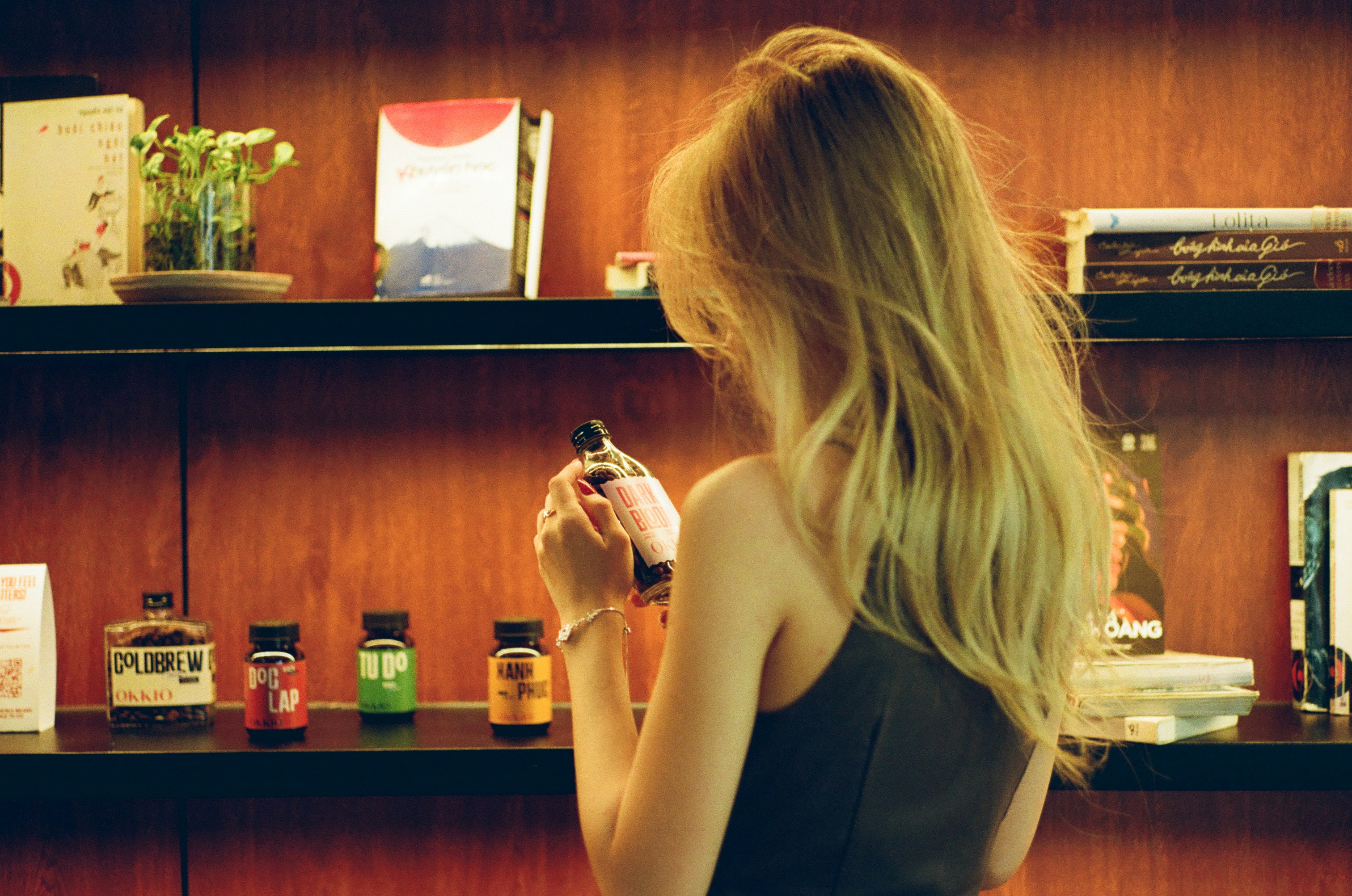 Woman examining a small bottle on a shelf