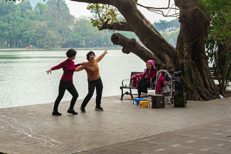 Senior adult practicing gentle tai chi movement in a bright park setting for balance and strength after 65