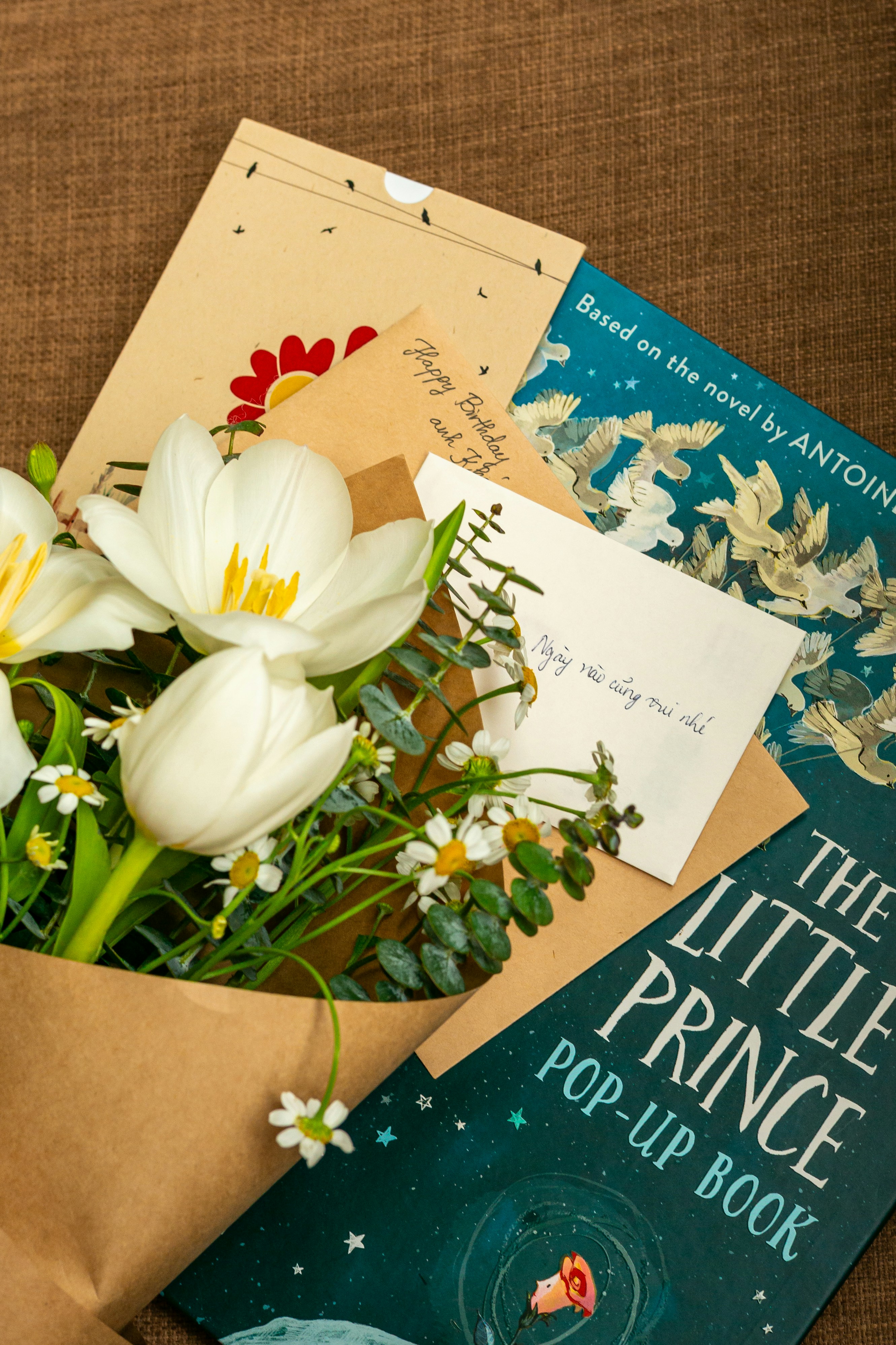 Tulipes blanches et cartes de vœux sur une surface brune