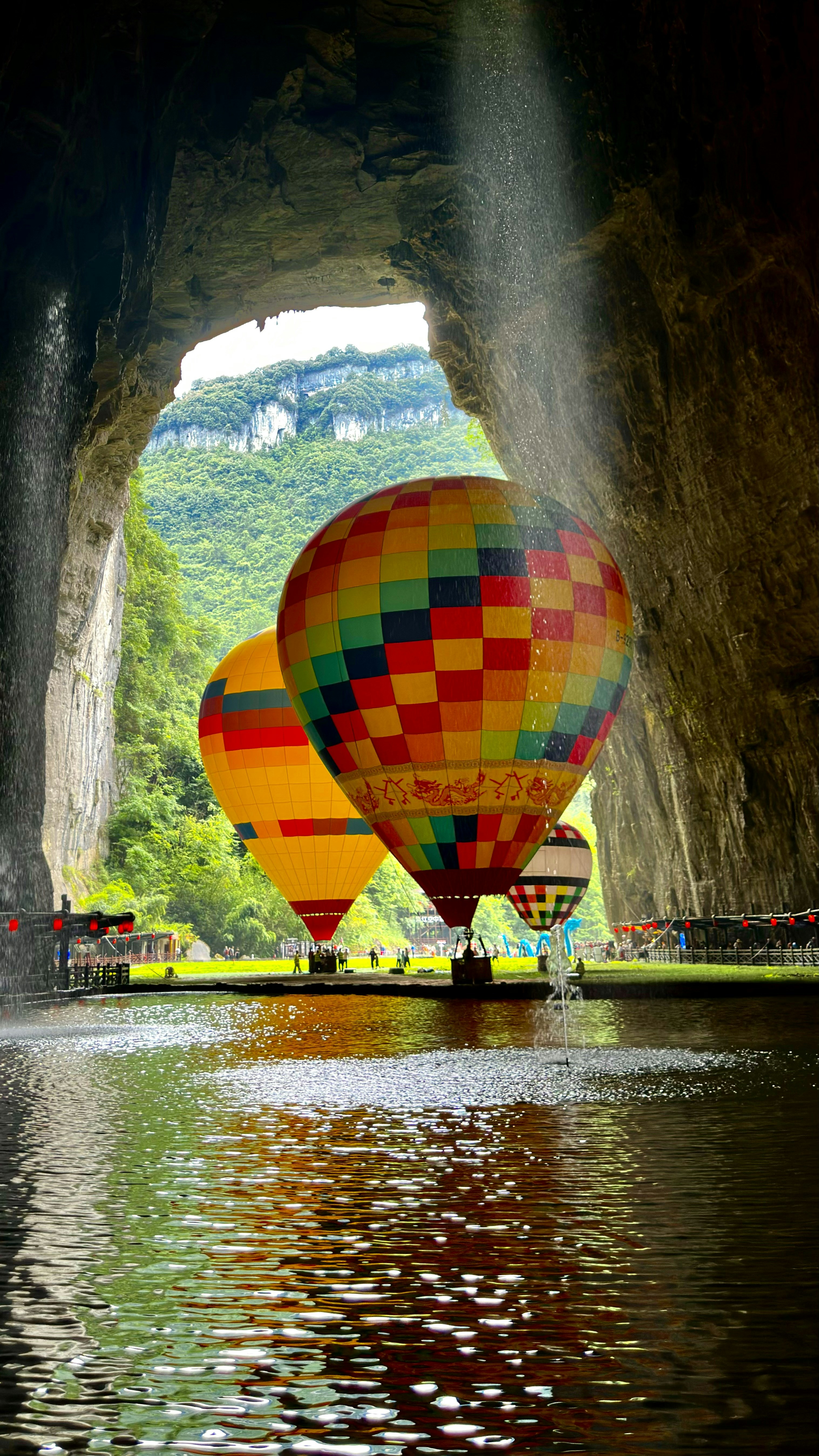 Balon udara berwarna-warni mengambang di atas air di dalam gua.