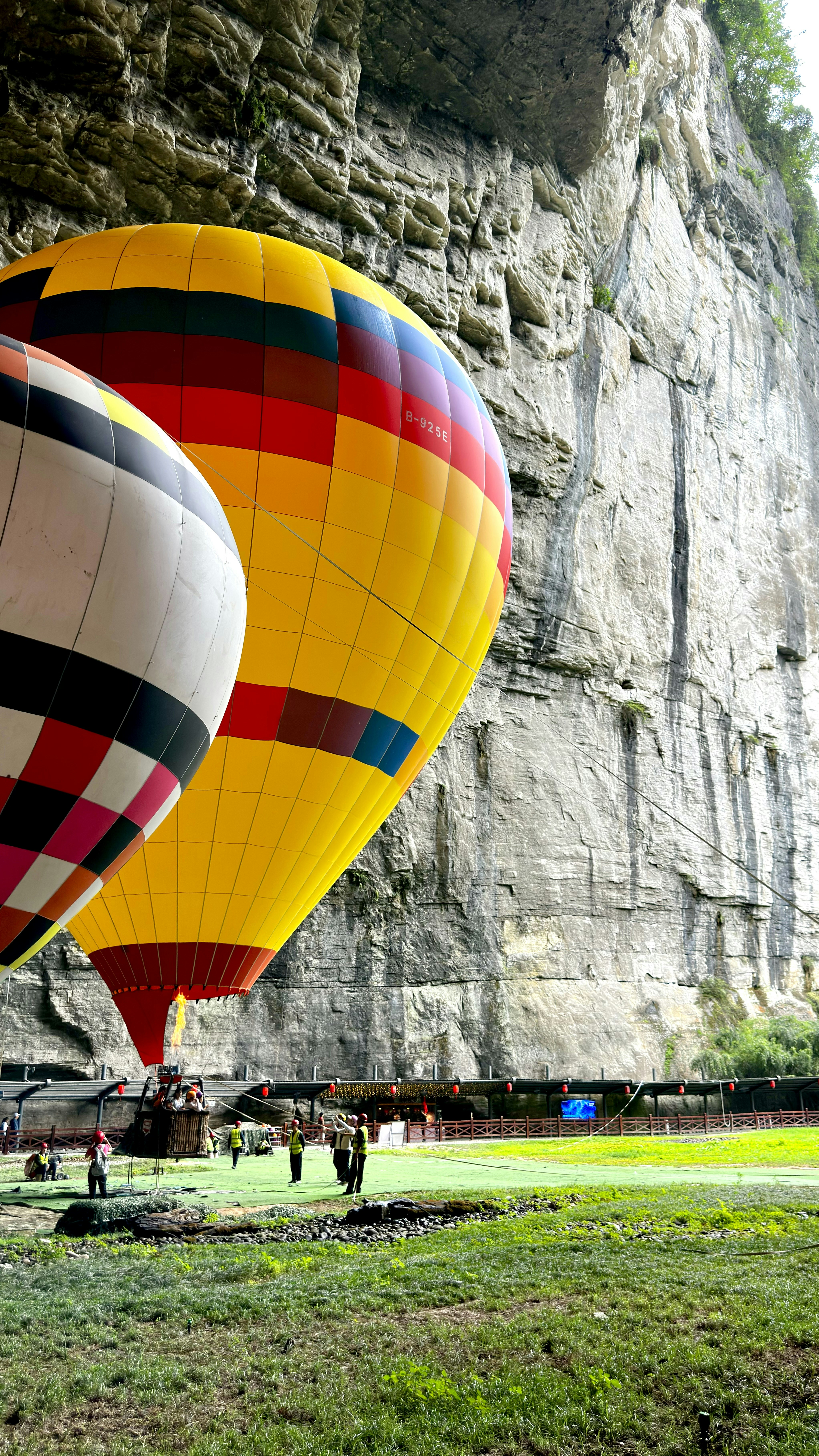 Dua balon udara bersiap untuk terbang di dekat tebing.