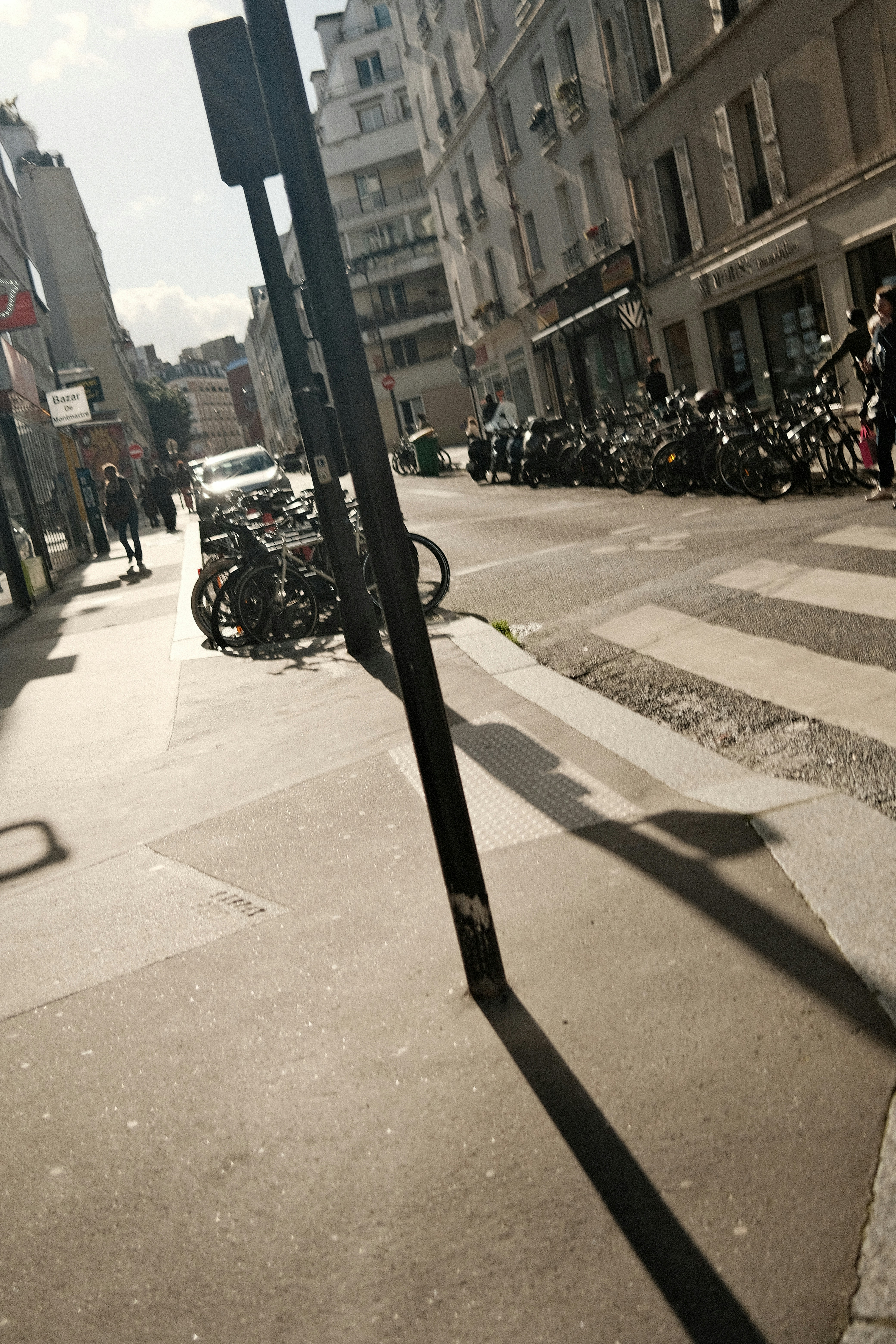 Cena de rua com bicicletas estacionadas e faixa de pedestres