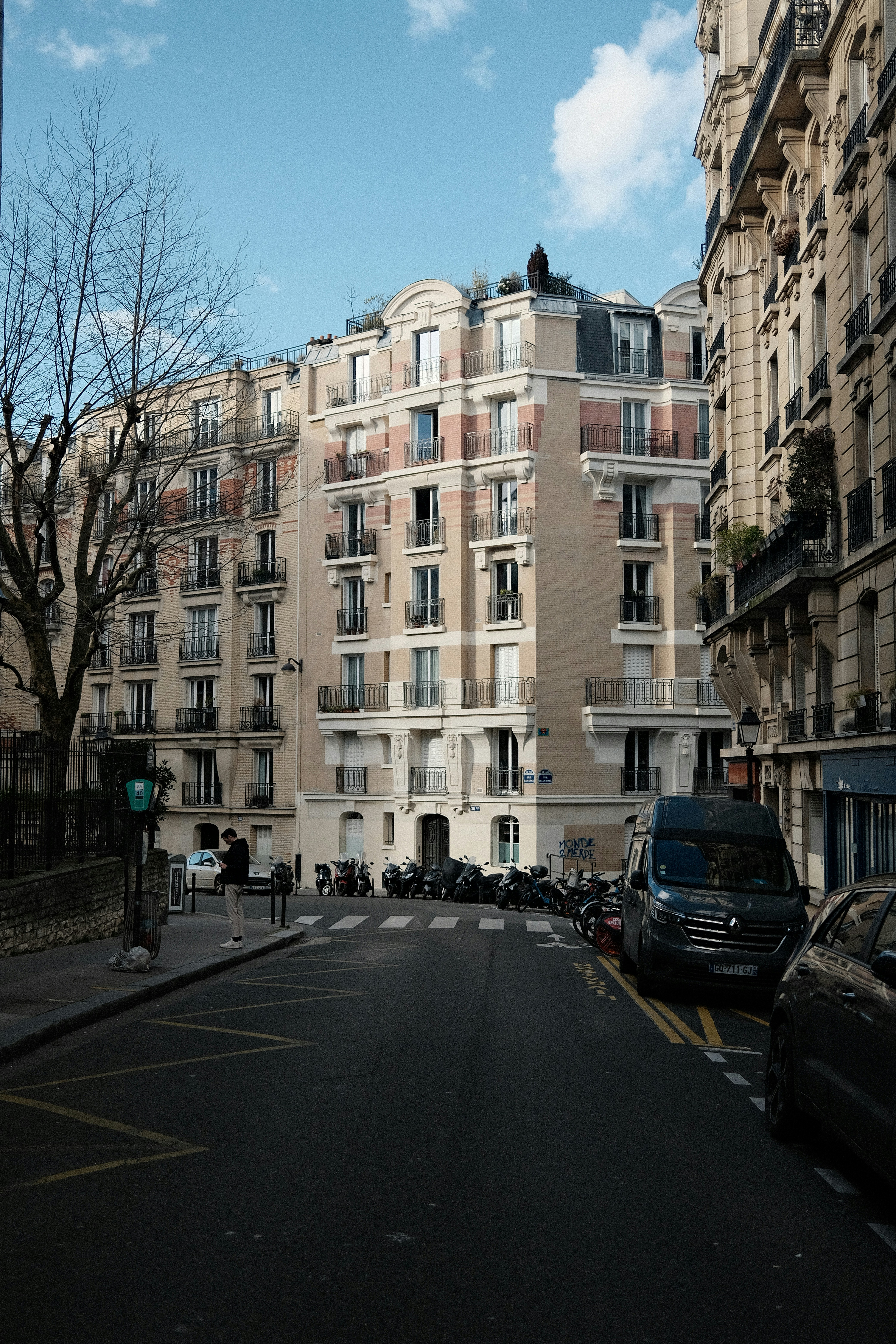 Prédios de apartamentos alinham uma rua com motocicletas estacionadas.