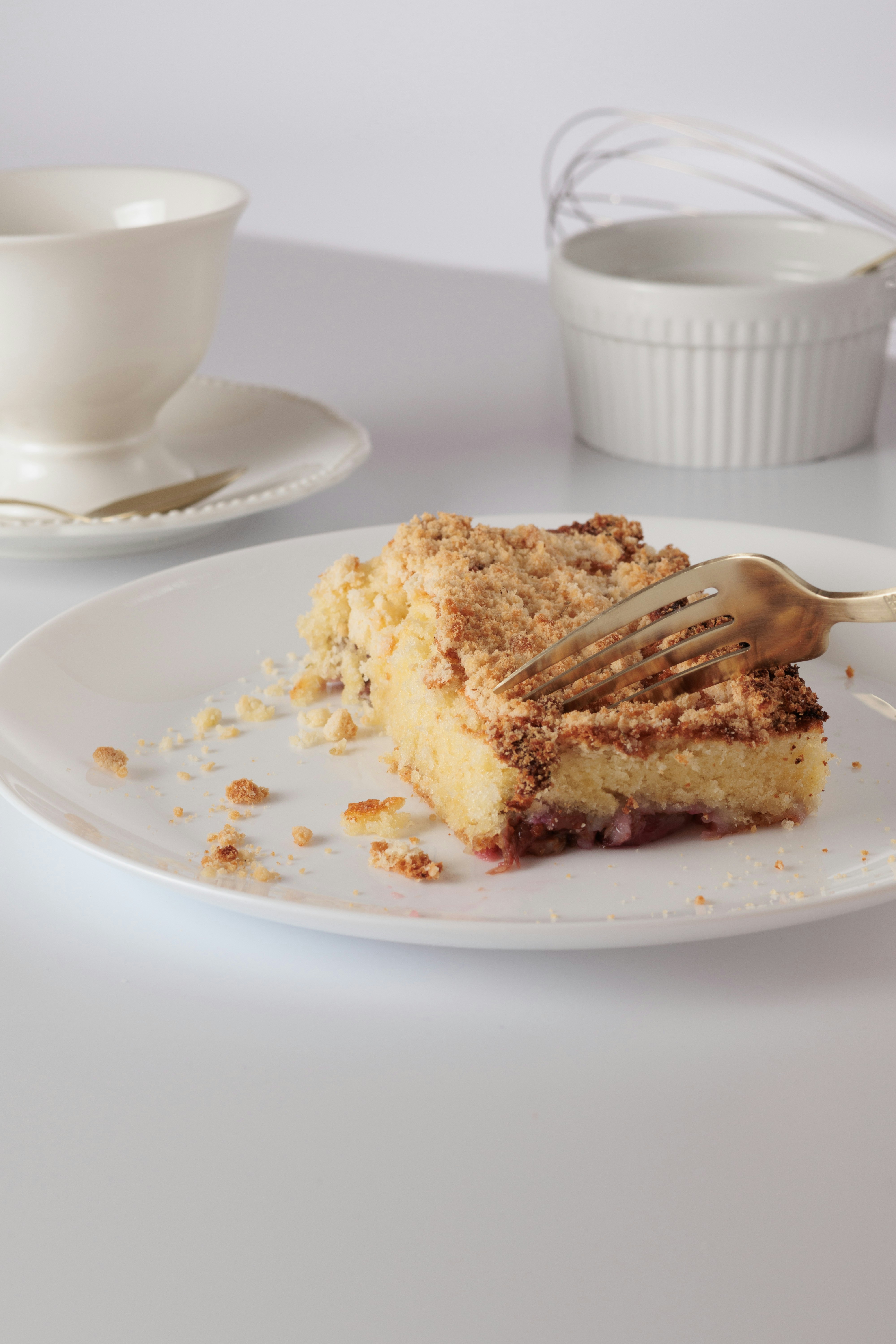 A fork cuts into a slice of crumb cake.