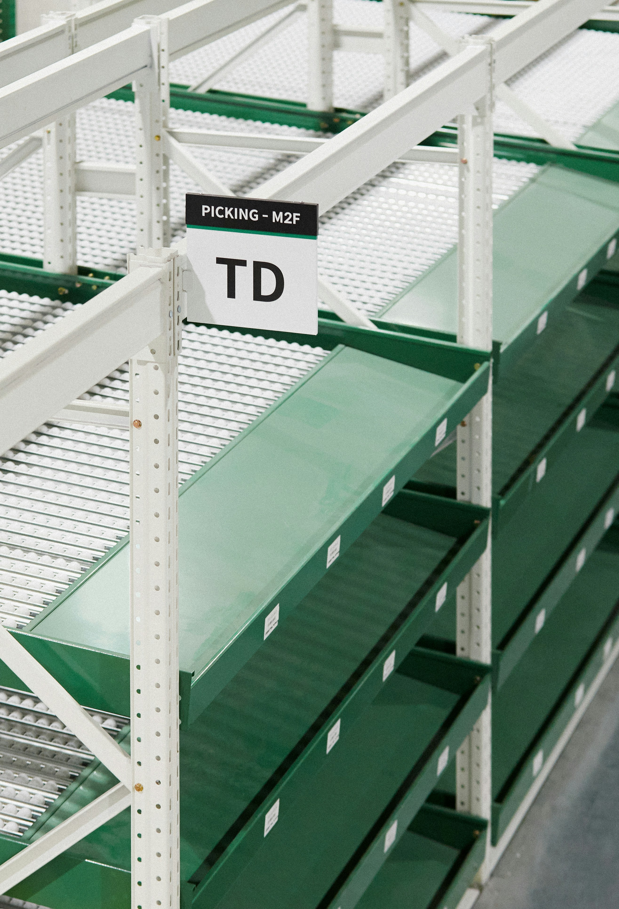 Empty green shelves in a warehouse with signs