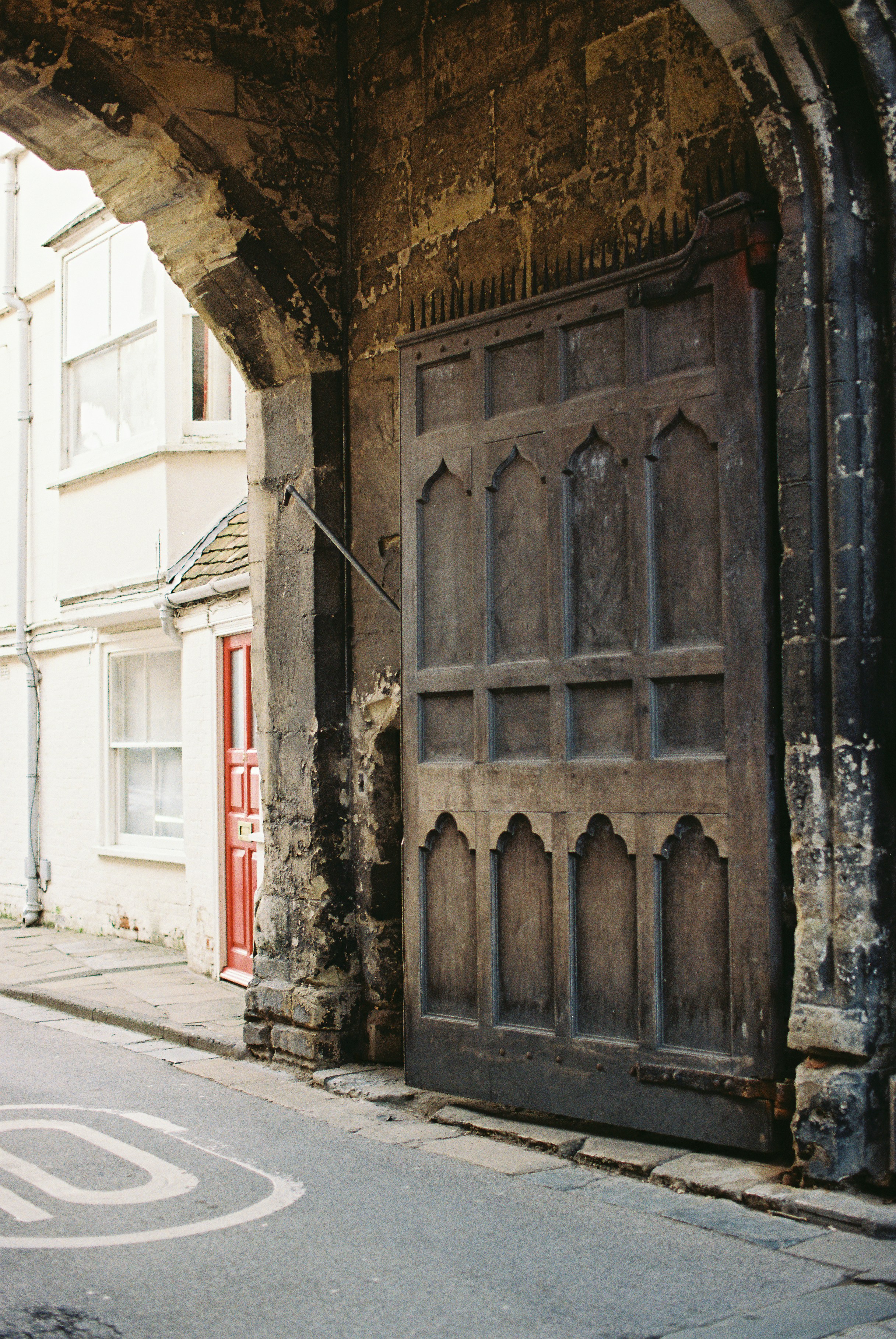 Large wooden gate under stone archway on street photo – Free ...
