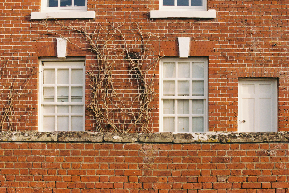 Red brick house wall with white windows