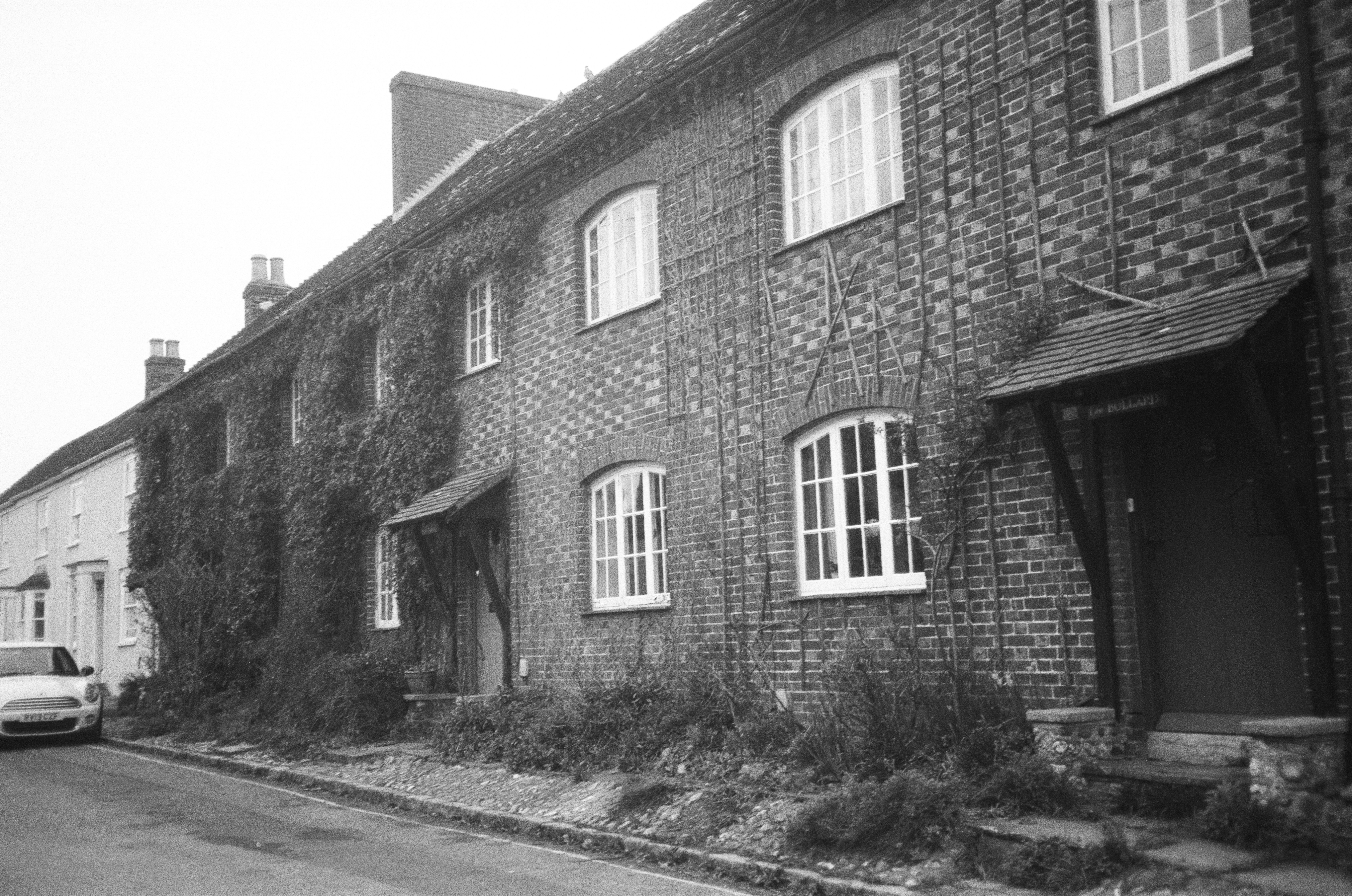 Reihe alter Backsteinhäuser mit Efeu und weißen Fenstern