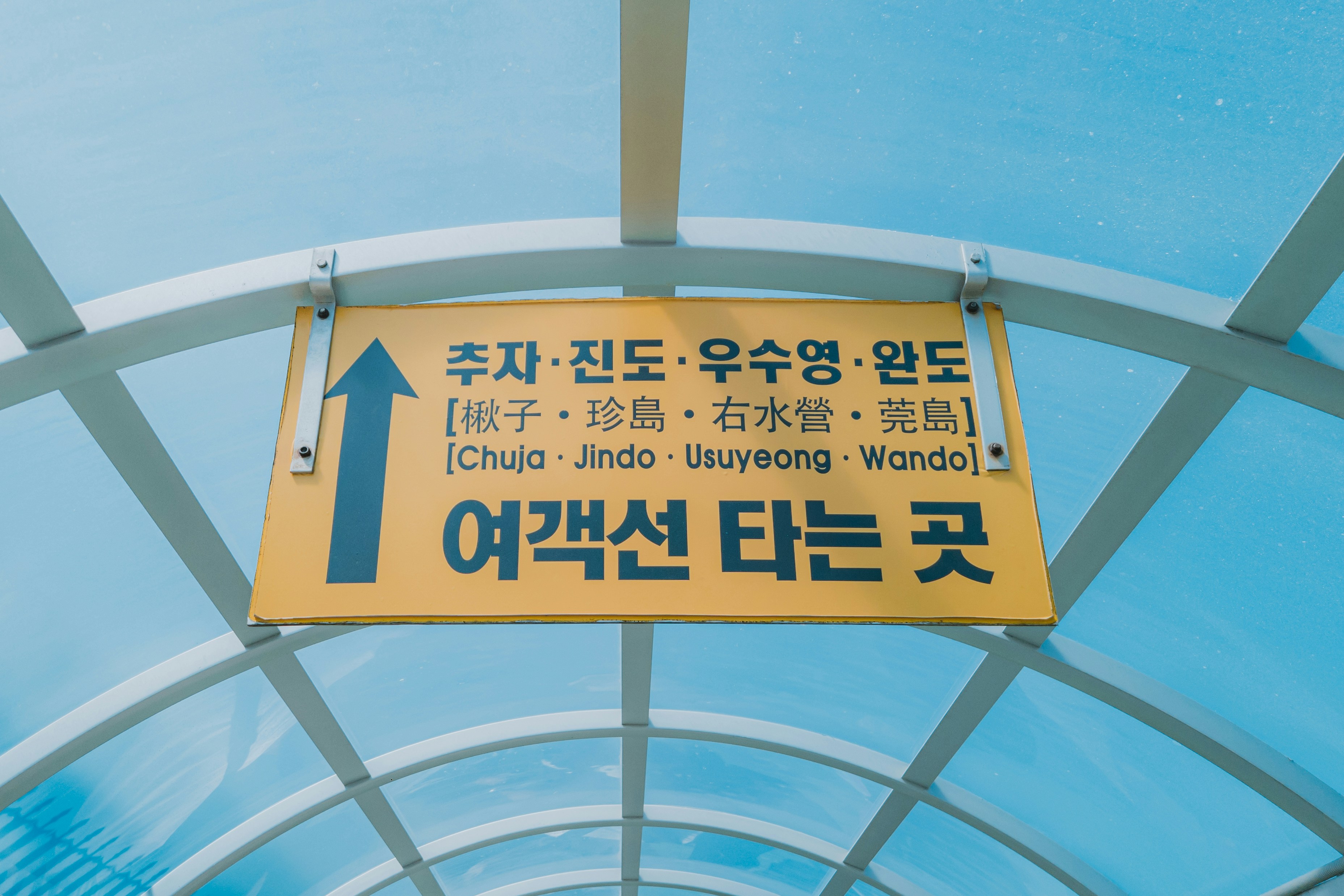 Yellow sign with korean text and arrow pointing up