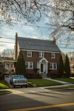 Brick house with a blue truck in the driveway.