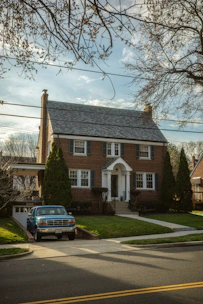Brick house with a blue truck in the driveway.