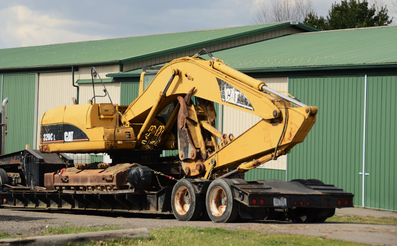 Excavator chained down on a lowboy flatbed trailer