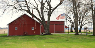 Red barn with american flag in rural setting