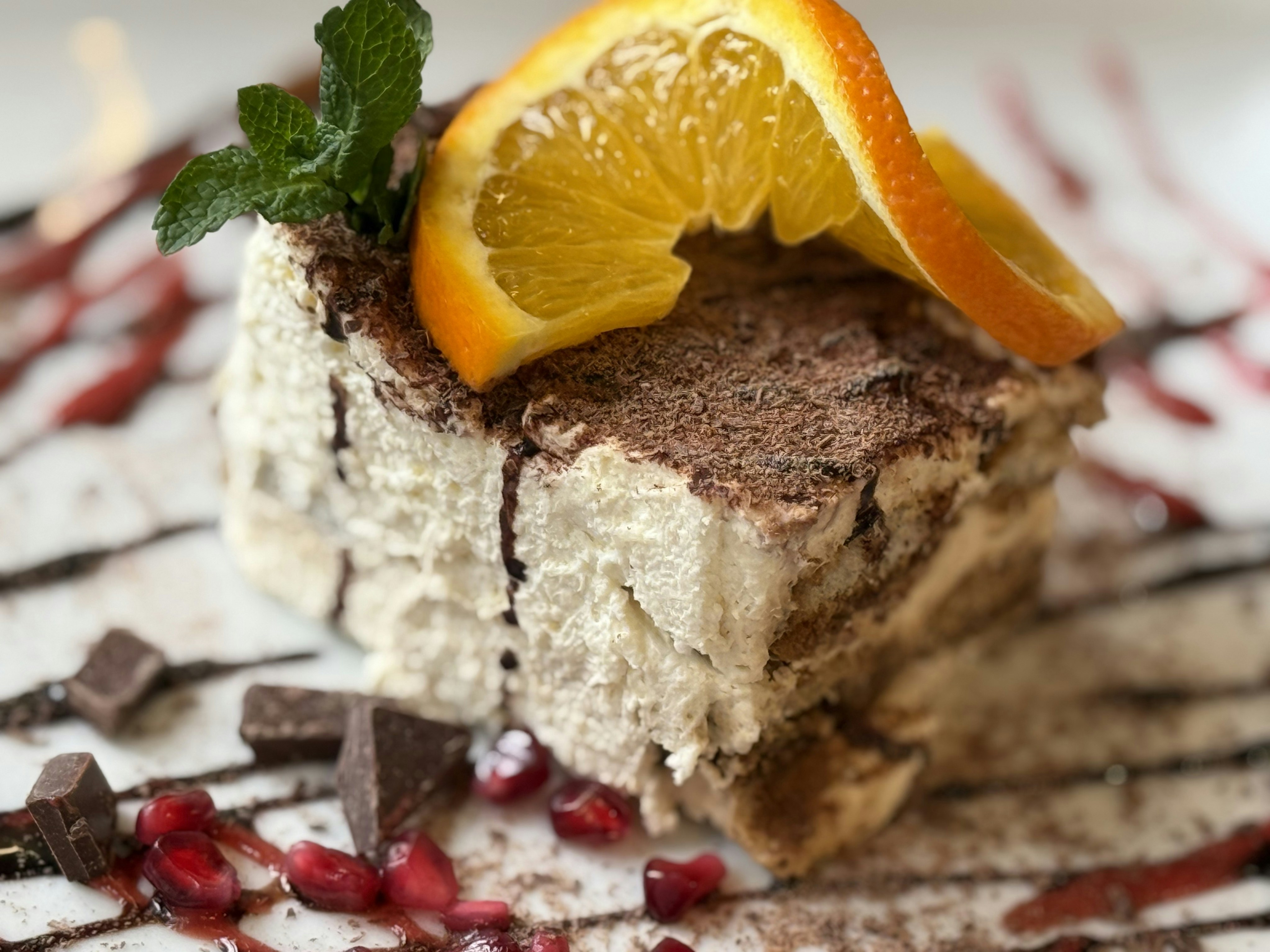 Tiramisu dessert with orange slices and mint