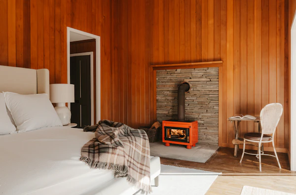 A cosy wood-panelled bedroom with a fireplace