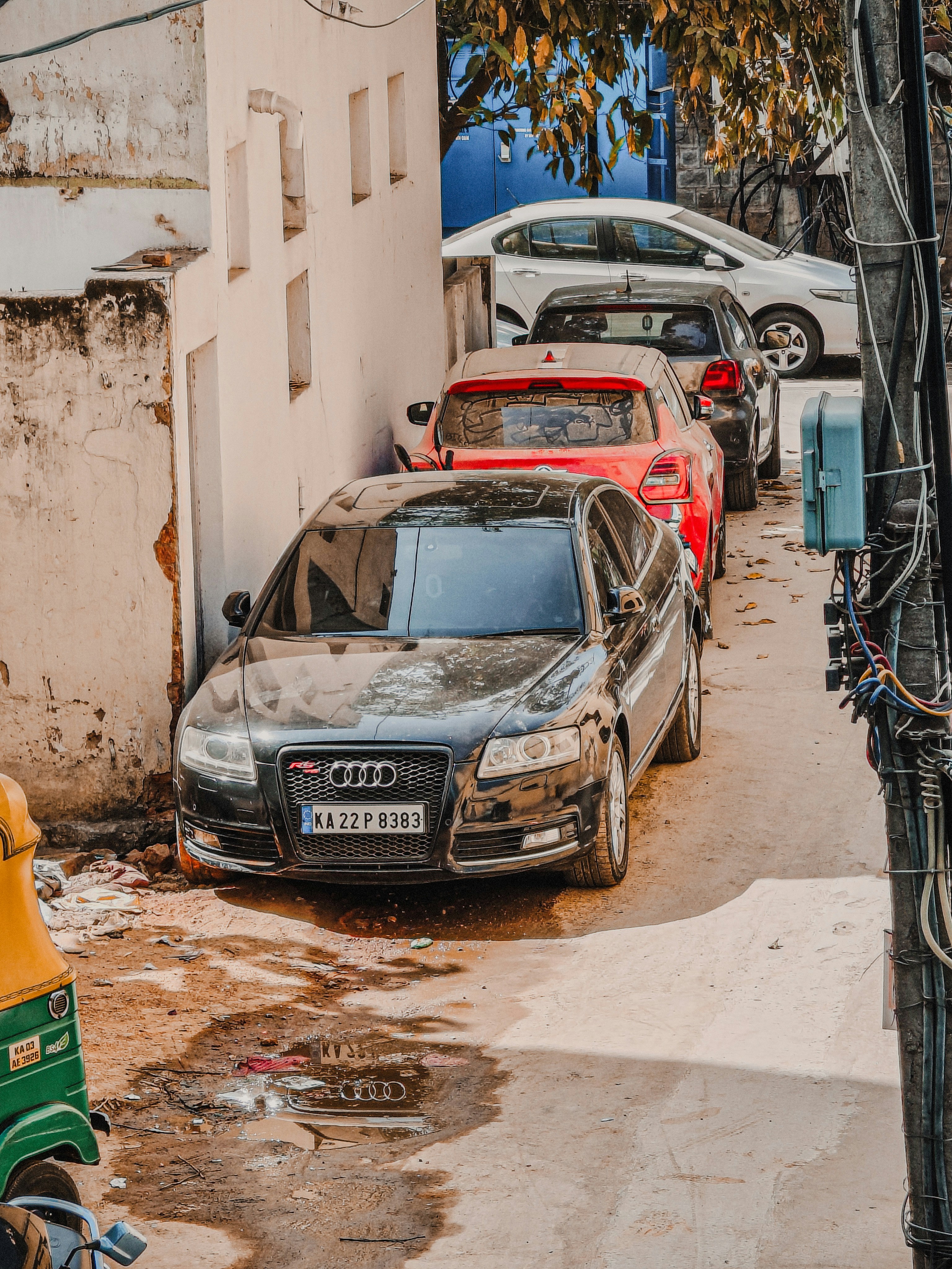 Several cars parked on a narrow street.