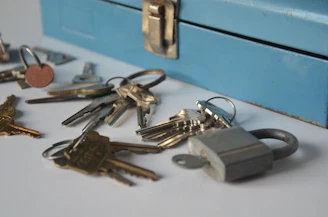 Keys and a padlock near a blue toolbox