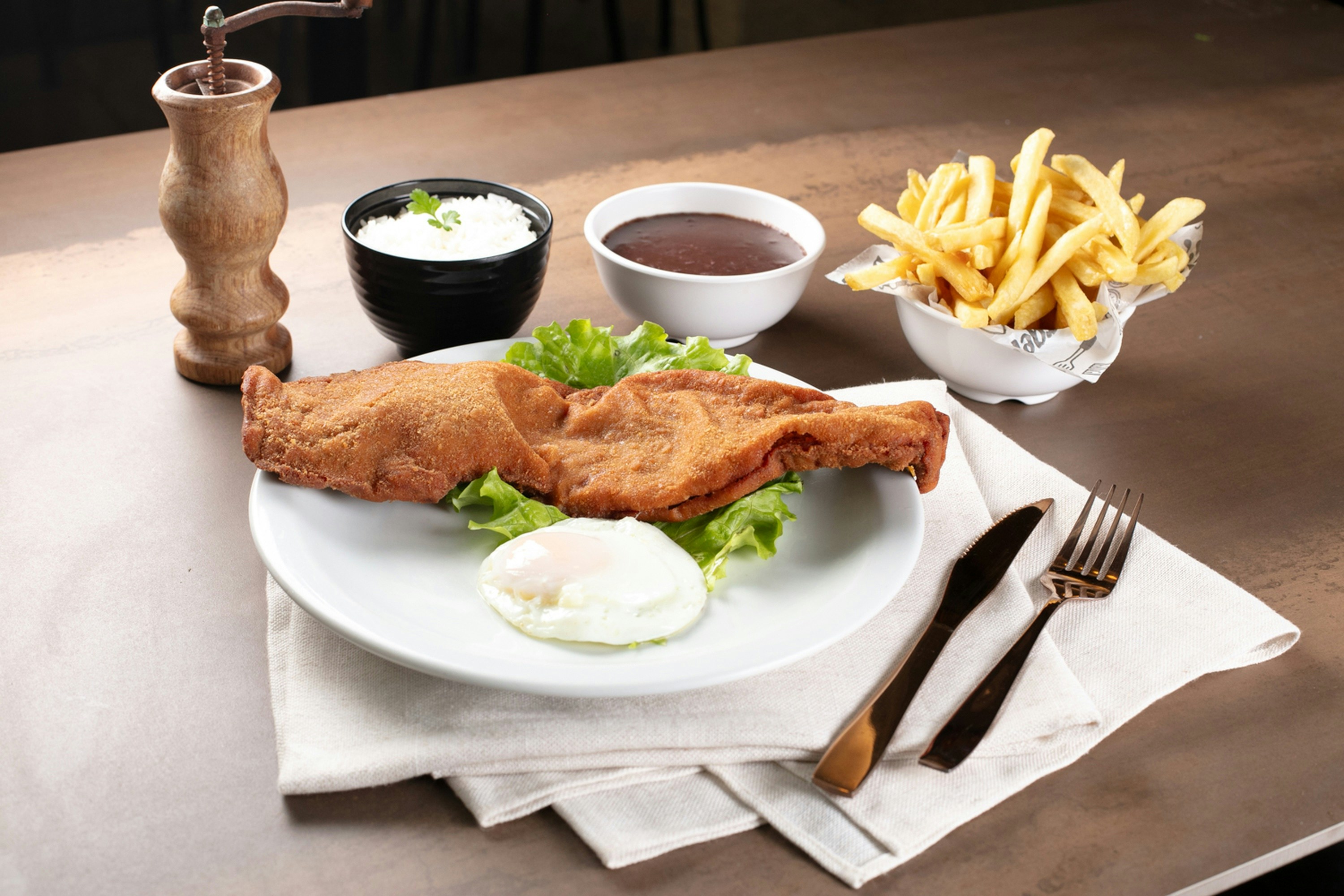 Breaded schnitzel with fries and sauces onsen tamago.