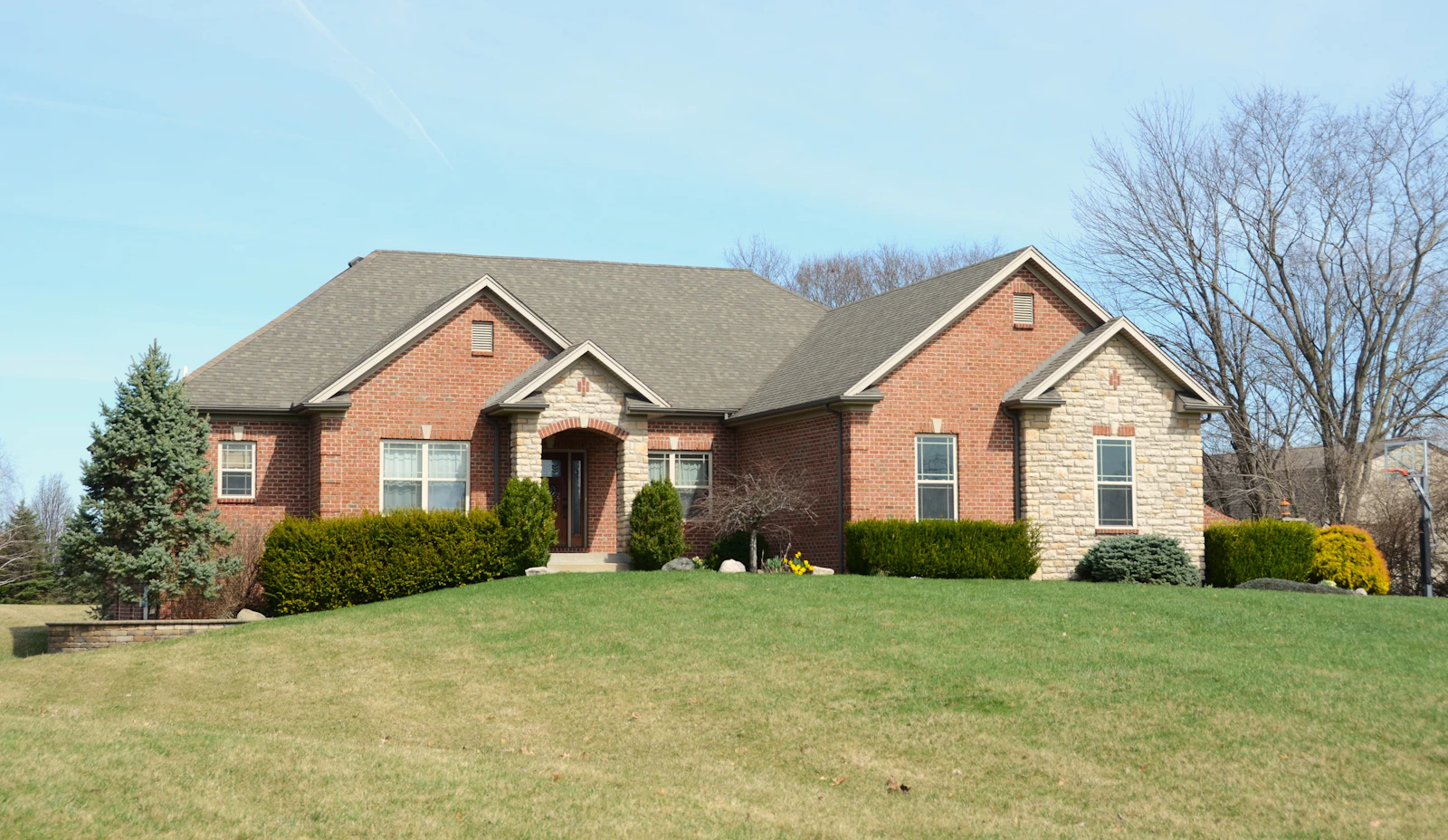 Large brick home with a manicured green front lawn