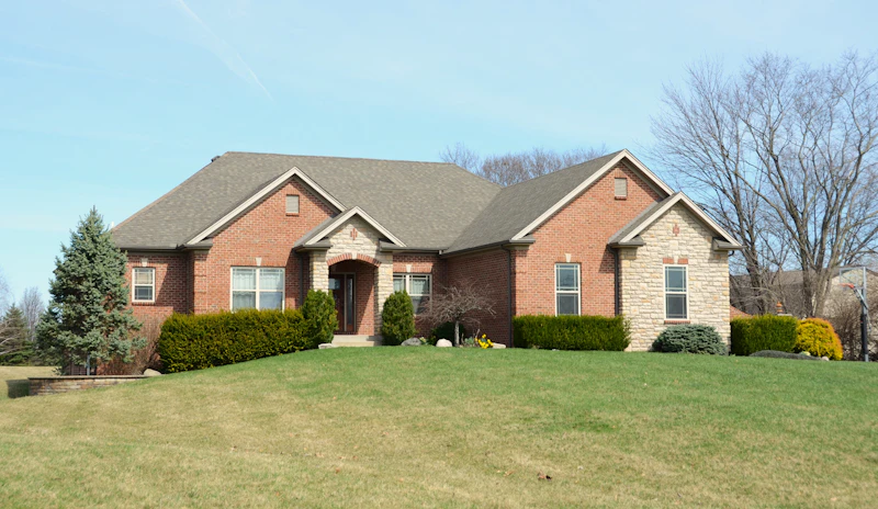 Clean brick ranch home with bright siding on a sunny day