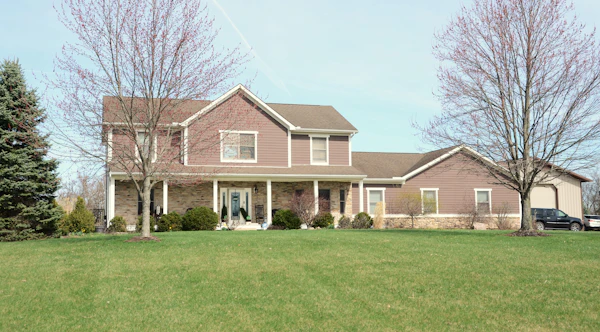 Large suburban luxury home with a spacious green lawn