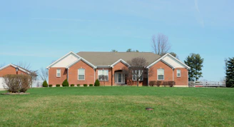 A large brick house with a manicured lawn.