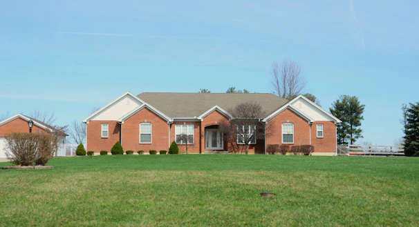 A large brick house with a manicured lawn.