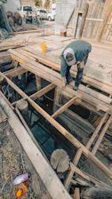 Man working on wooden structure over water