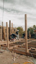 Construction workers build a wooden deck outdoors.