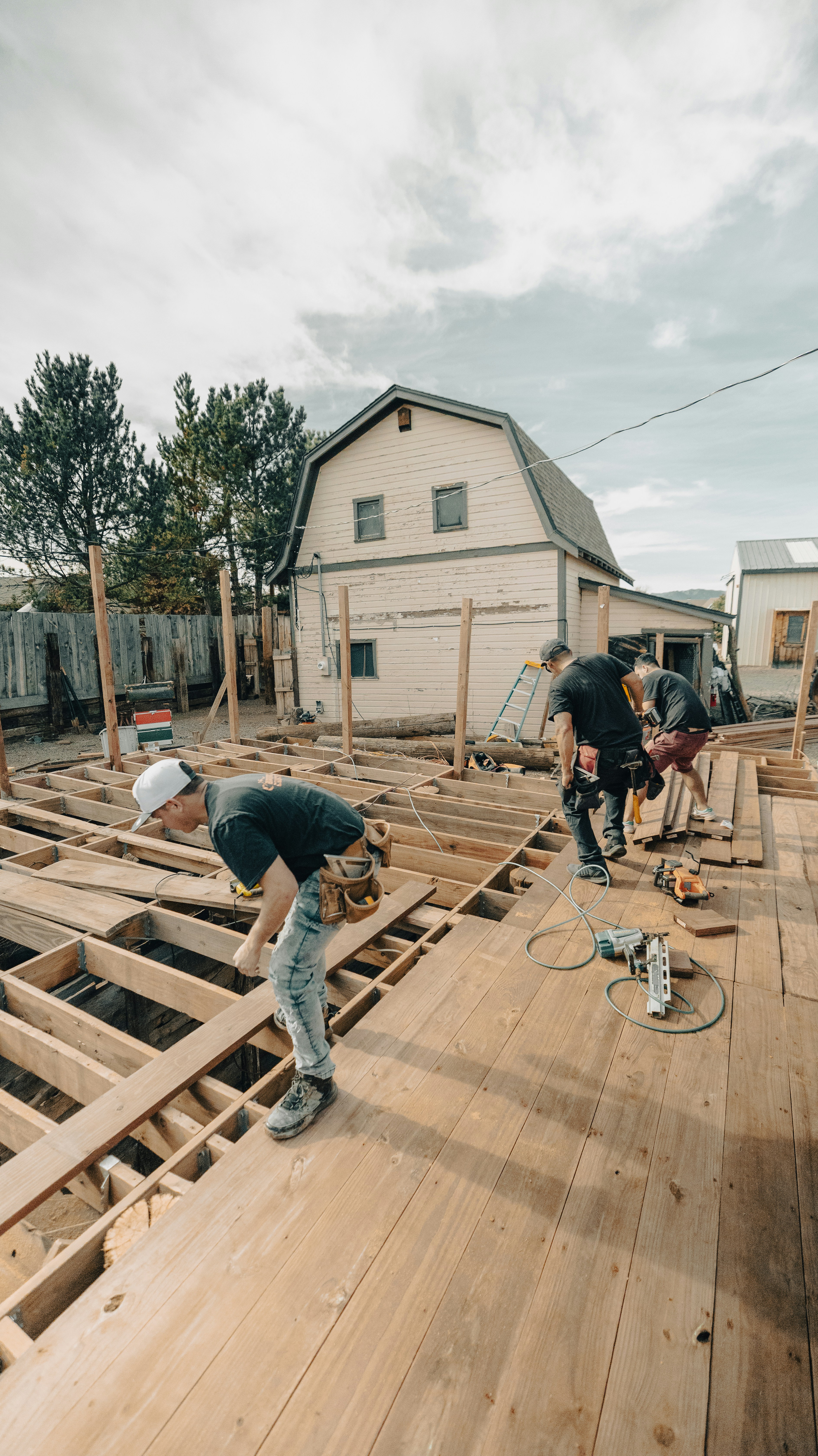 Construction workers building a wooden deck outdoors