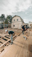 Construction workers building a wooden deck outdoors