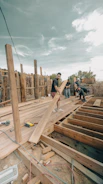 Construction workers building a wooden deck outdoors.