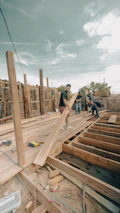 Construction workers building a wooden deck outdoors.