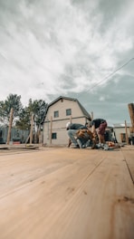 Construction workers building a wooden deck near a house.