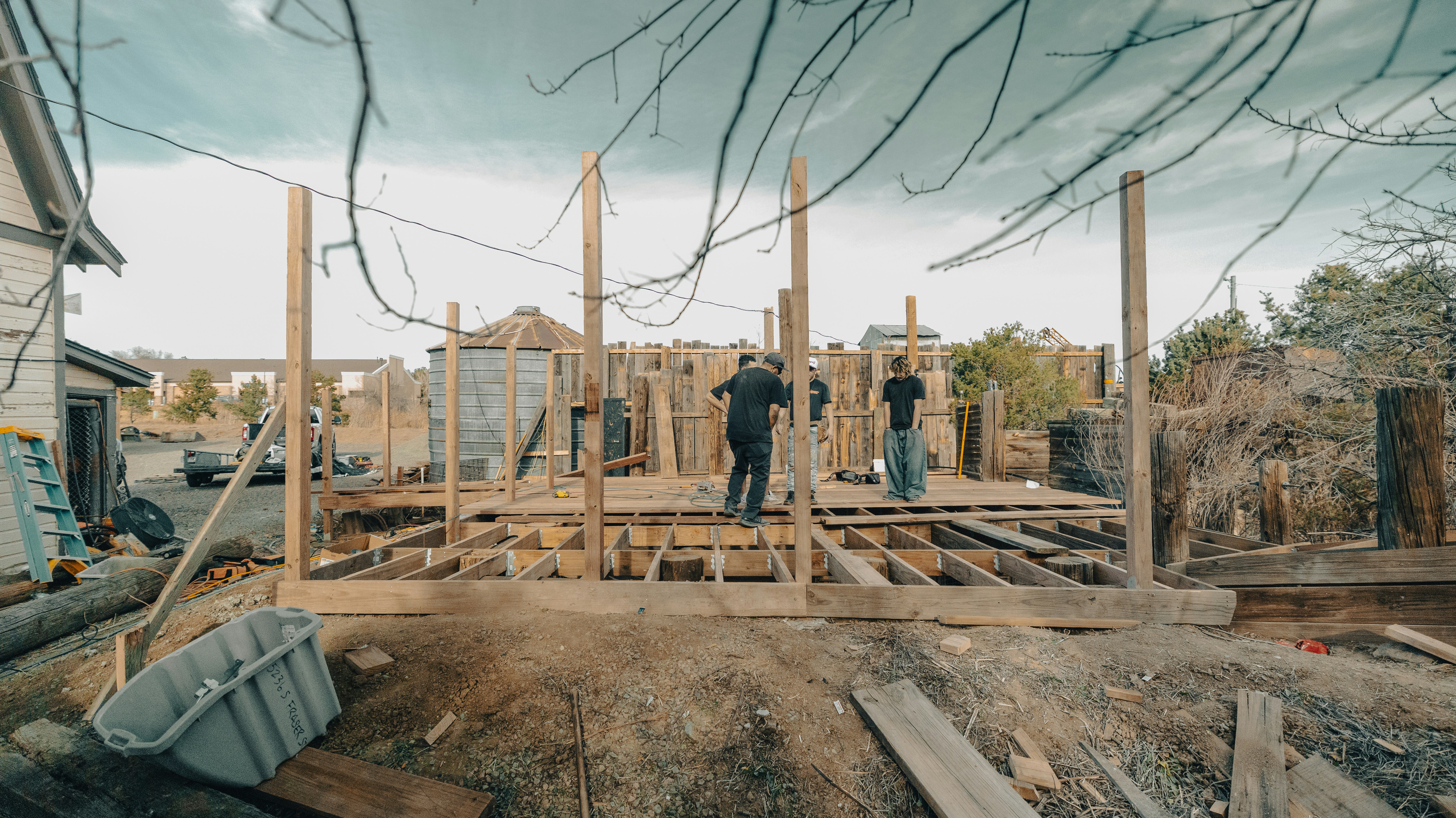 Construction workers building a wooden structure outdoors