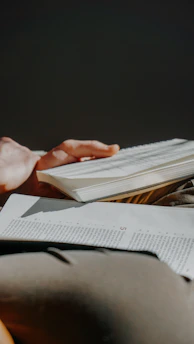 A person reading a book with pages open.